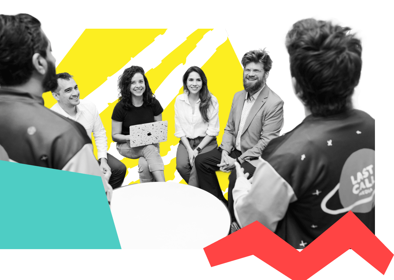 A group of people sitting and standing in a casual meeting setting. 