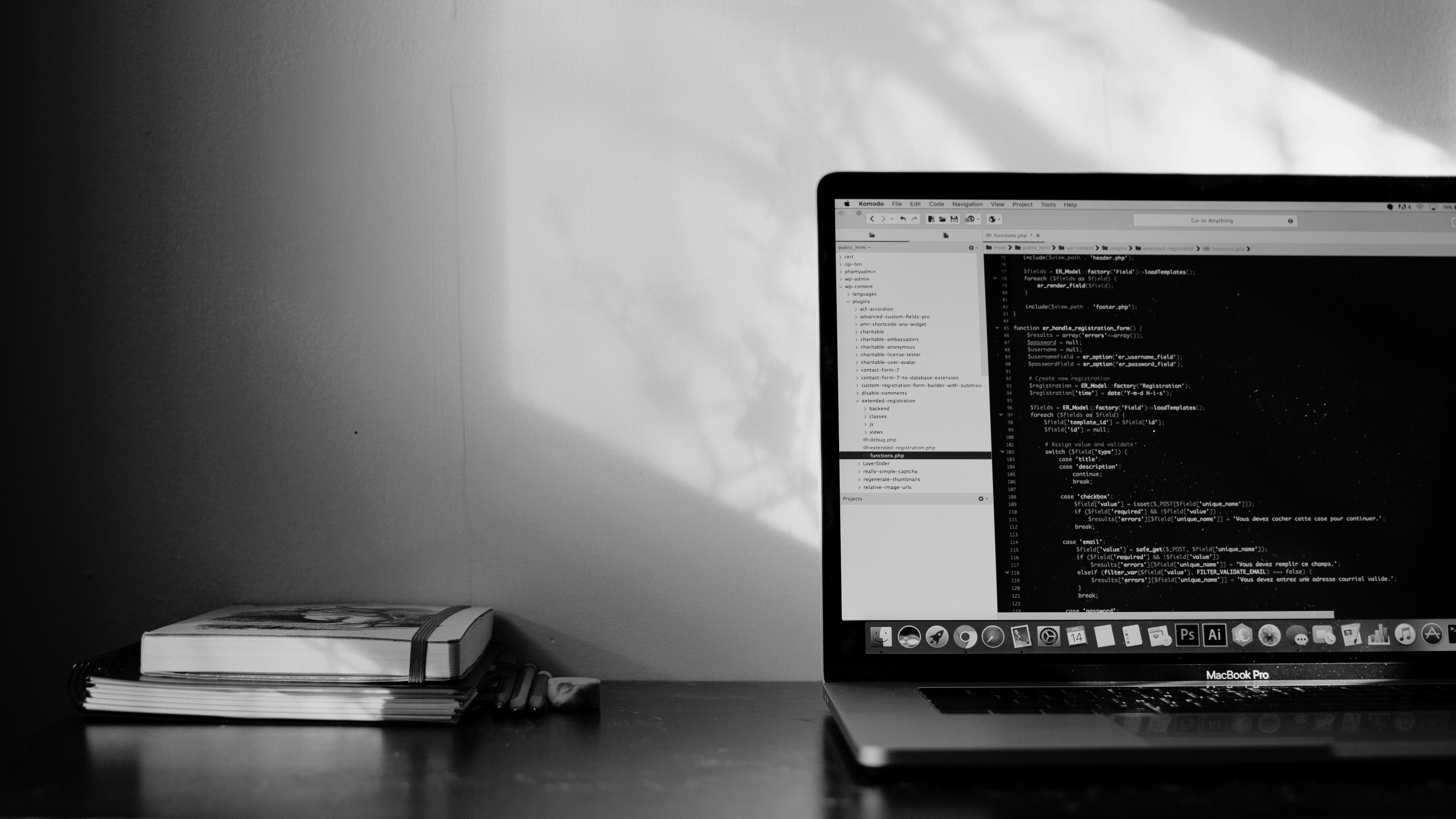 A black and white image of a laptop showing code on the screen