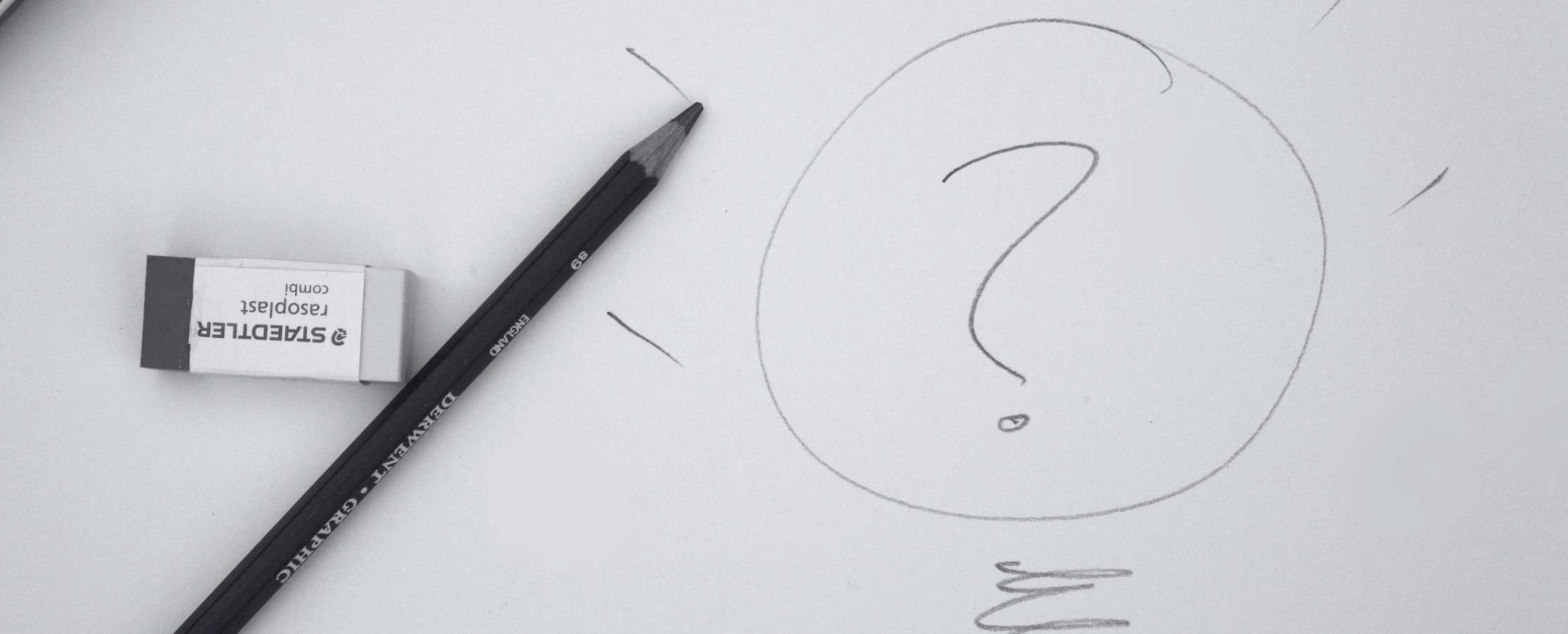 black and white image of a pencil and a drawing of a question mark inside a light bulb.