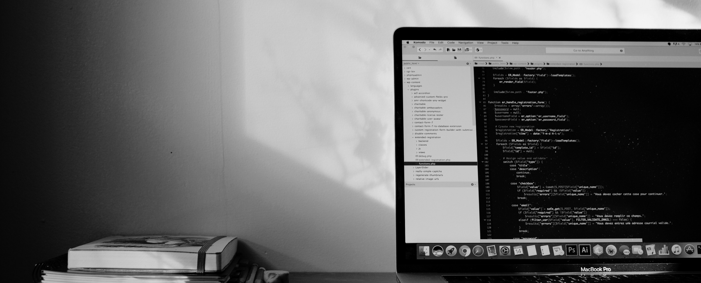 A black and white image of a laptop showing code on the screen
