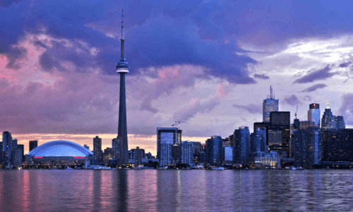 Toronto skyline against a colorful clouds at sunset.
