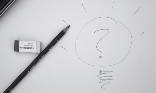black and white image of a pencil and a drawing of a question mark inside a light bulb.